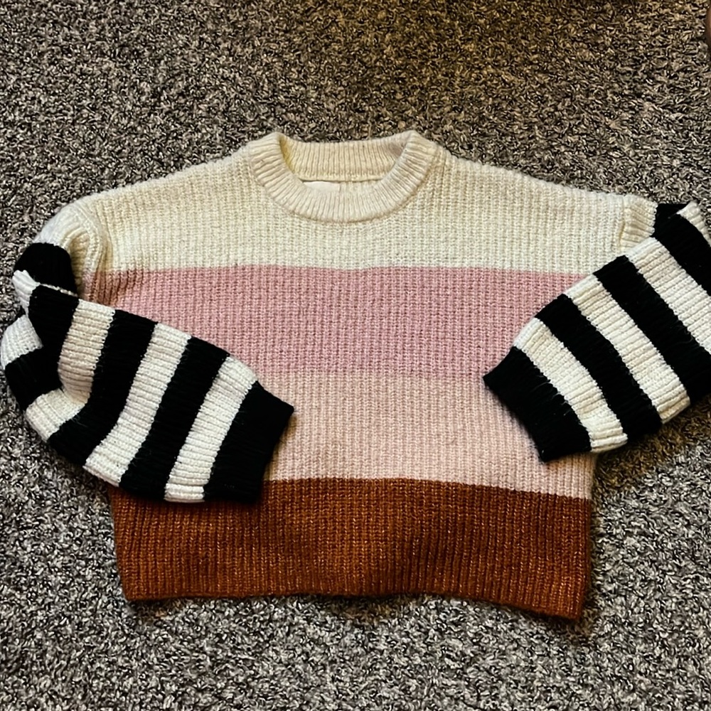 striped sweater, burnt orange,pink and white with black and white sleeves.